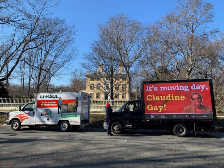 [卡尔]广告牌卡车停在前哈佛校长官邸外，上面写着今天是搬家日，克劳丁·盖伊